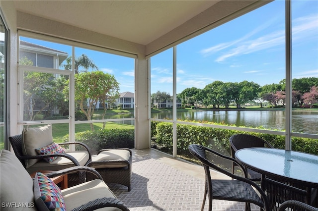 sunroom featuring a healthy amount of sunlight and a water view