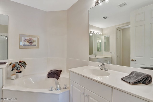 bathroom featuring vanity and independent shower and bath