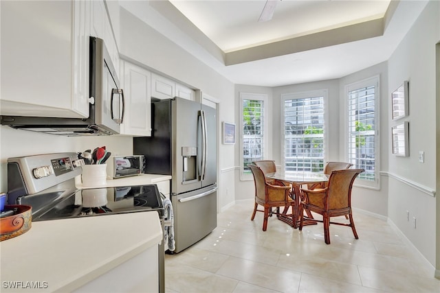 kitchen featuring white cabinetry, stainless steel appliances, and light tile patterned floors