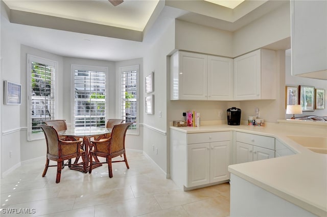 kitchen featuring white cabinets, light tile patterned floors, and sink