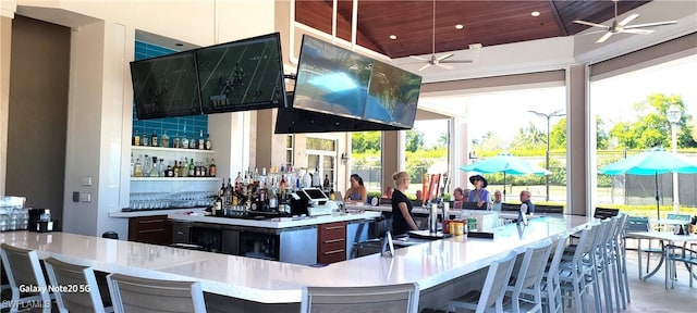 bar featuring vaulted ceiling, plenty of natural light, and wood ceiling