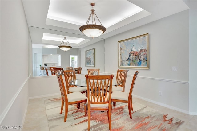 tiled dining room featuring a tray ceiling