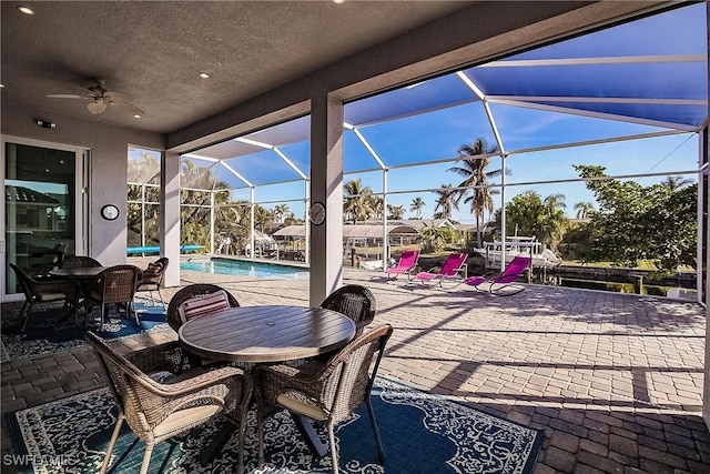 view of patio featuring a lanai and ceiling fan