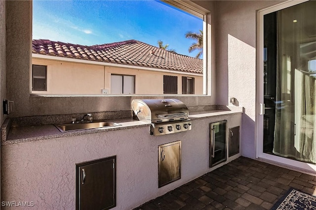 view of patio / terrace featuring a grill, sink, and exterior kitchen