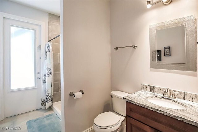 bathroom featuring vanity, toilet, and walk in shower