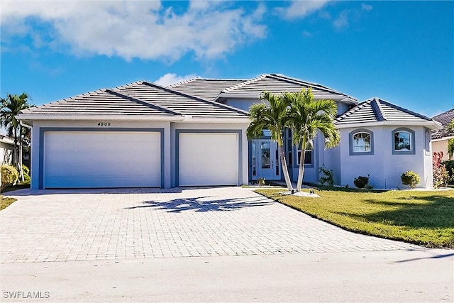 single story home featuring a garage and a front yard