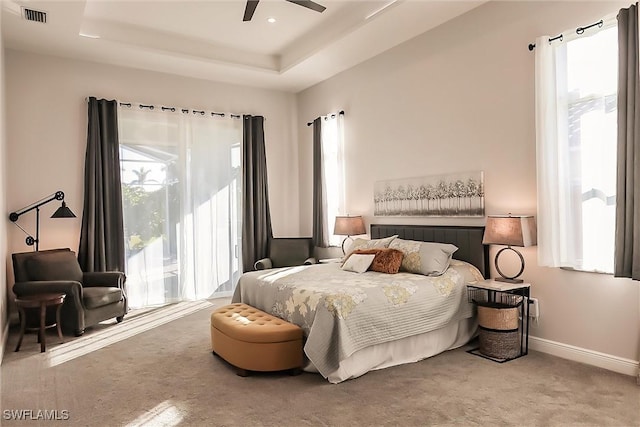 bedroom featuring carpet, ceiling fan, and a raised ceiling