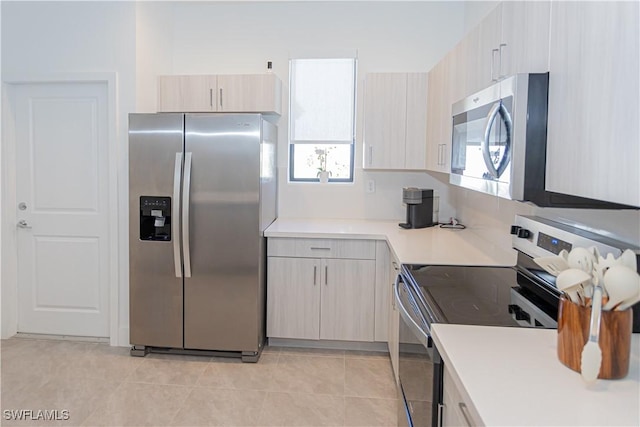 kitchen featuring a healthy amount of sunlight, light tile patterned flooring, and appliances with stainless steel finishes