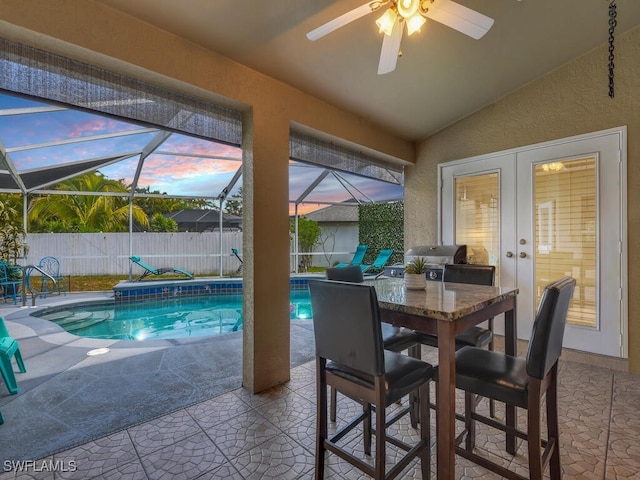 pool at dusk featuring ceiling fan and french doors