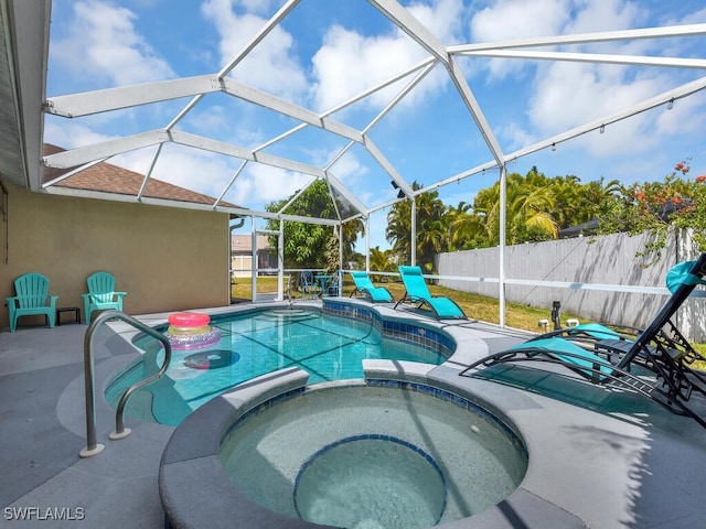 view of pool featuring glass enclosure, an in ground hot tub, and a patio area