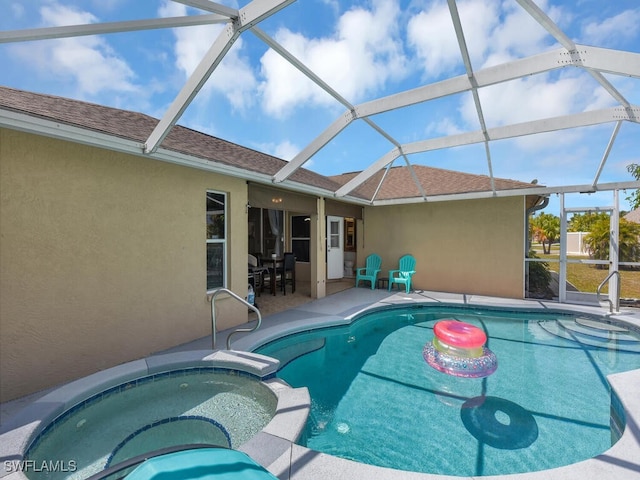 view of swimming pool featuring glass enclosure, an in ground hot tub, and a patio