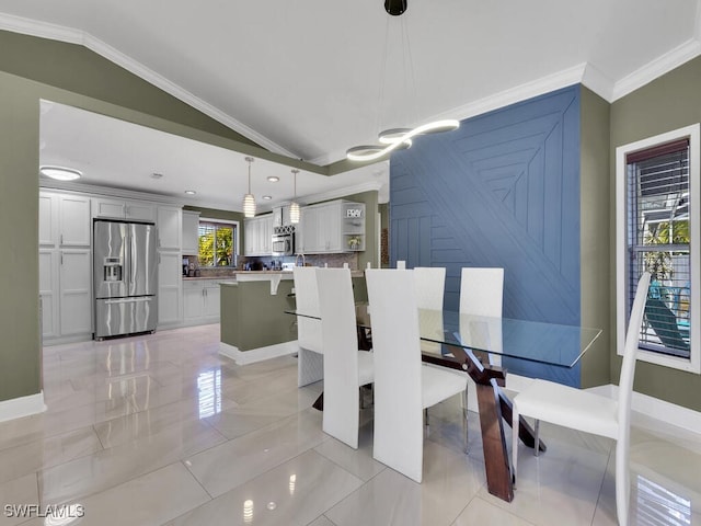 dining area featuring a healthy amount of sunlight, vaulted ceiling, and ornamental molding