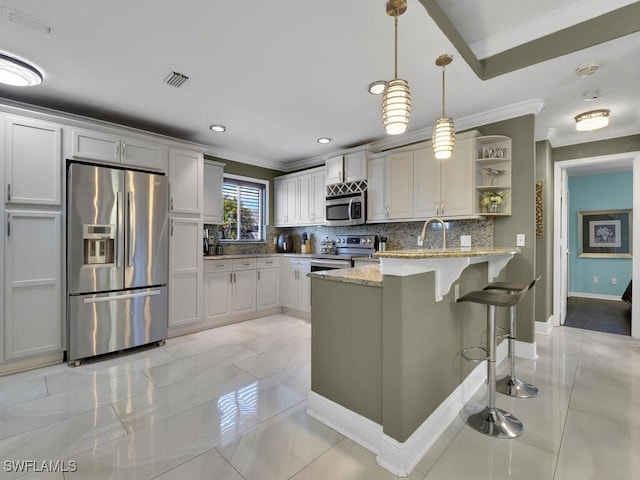 kitchen with light stone countertops, appliances with stainless steel finishes, white cabinets, and decorative light fixtures