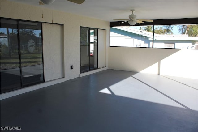 unfurnished sunroom with ceiling fan