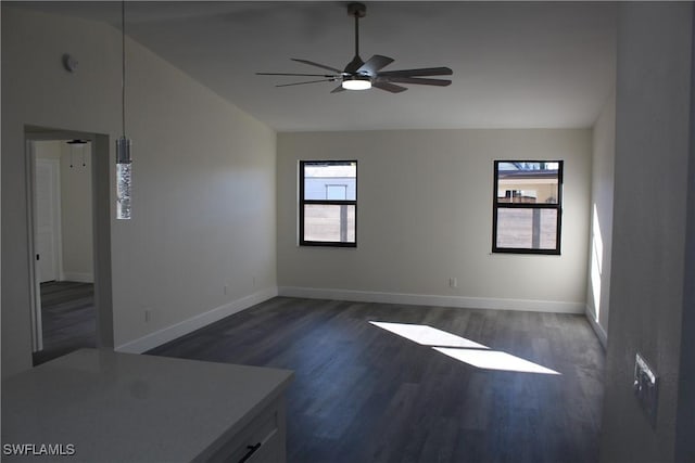 empty room with lofted ceiling, ceiling fan, and dark hardwood / wood-style floors