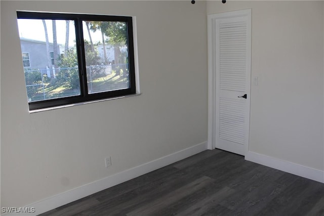 unfurnished bedroom featuring dark wood-type flooring and a closet