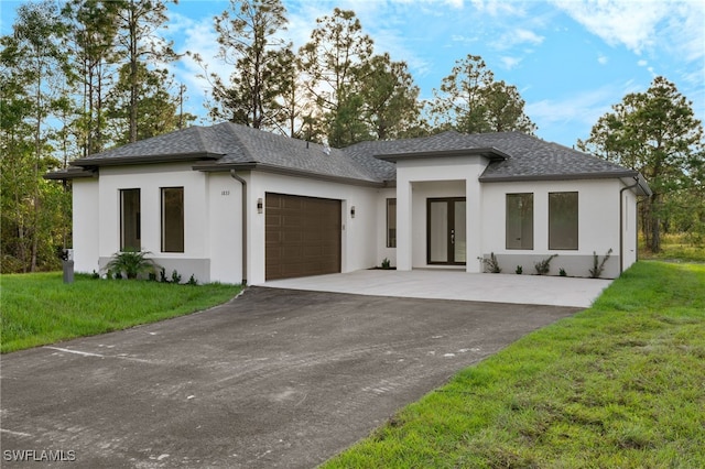 prairie-style house featuring a garage and a front lawn