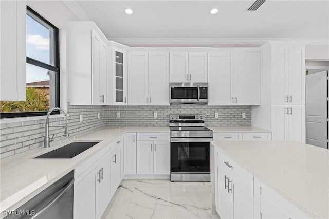 kitchen with white cabinetry, sink, light stone counters, and appliances with stainless steel finishes