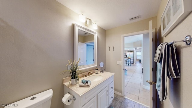 bathroom featuring tile patterned flooring, vanity, and toilet