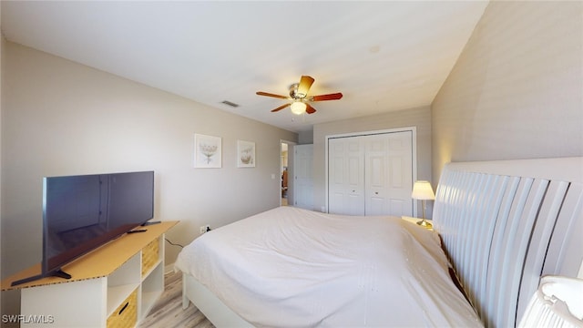 bedroom featuring a closet, light hardwood / wood-style flooring, and ceiling fan