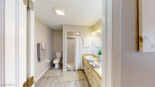 bathroom featuring a shower with curtain, hardwood / wood-style floors, vanity, and toilet