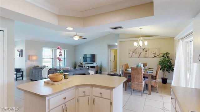 kitchen with light brown cabinetry, ceiling fan with notable chandelier, a center island, and light tile patterned flooring