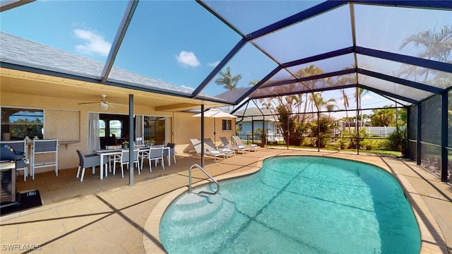 view of swimming pool featuring ceiling fan, a patio area, and glass enclosure