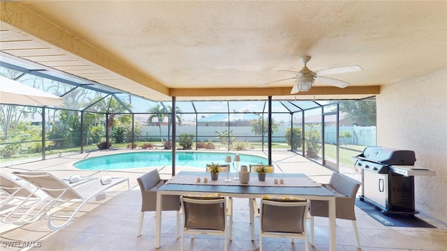 view of swimming pool with a patio, glass enclosure, ceiling fan, and a grill