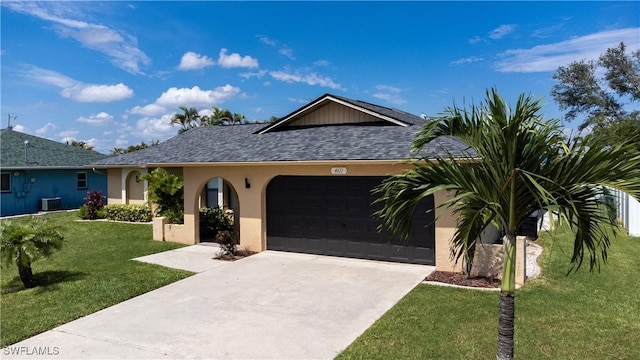 ranch-style home with cooling unit, a front yard, and a garage