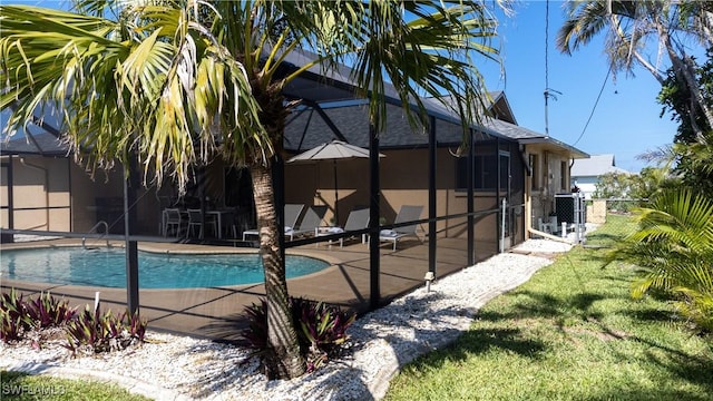 view of swimming pool with glass enclosure and a patio