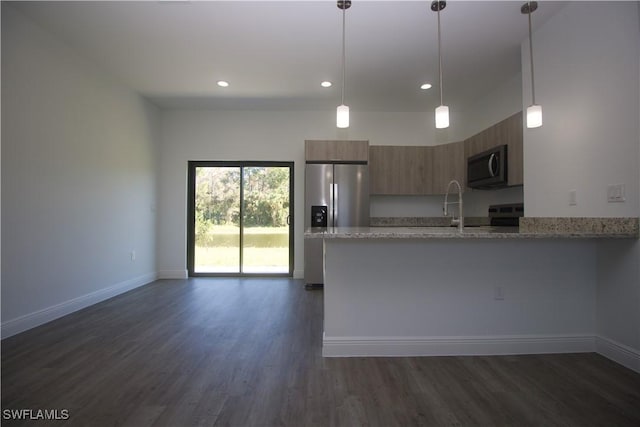 kitchen featuring light stone countertops, kitchen peninsula, stainless steel appliances, pendant lighting, and dark hardwood / wood-style floors