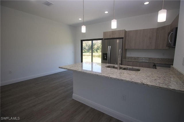 kitchen with appliances with stainless steel finishes, decorative light fixtures, dark hardwood / wood-style floors, and sink