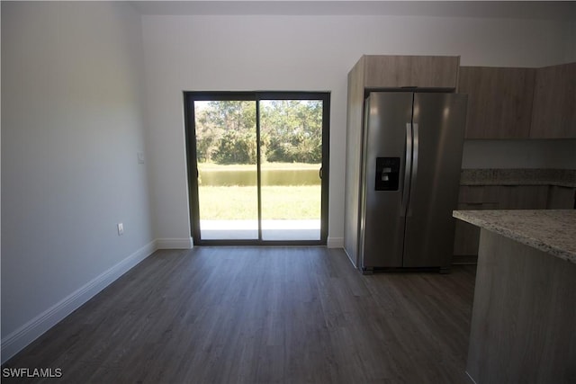 kitchen featuring dark hardwood / wood-style flooring, light stone countertops, and stainless steel refrigerator with ice dispenser