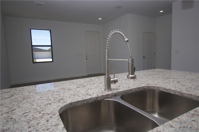 details featuring light stone counters and sink