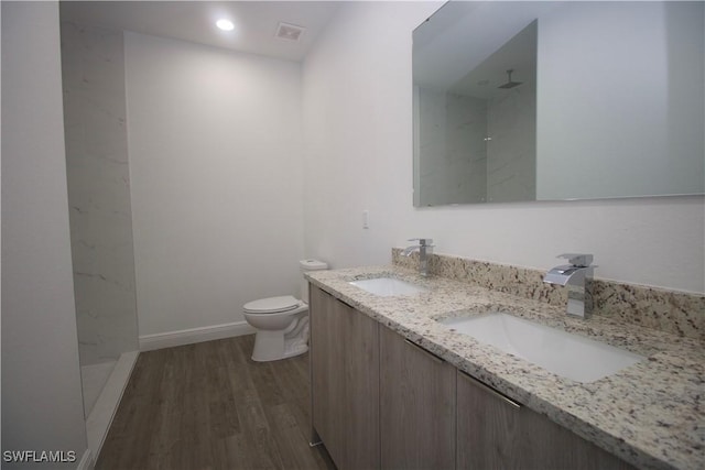 bathroom featuring vanity, toilet, wood-type flooring, and walk in shower