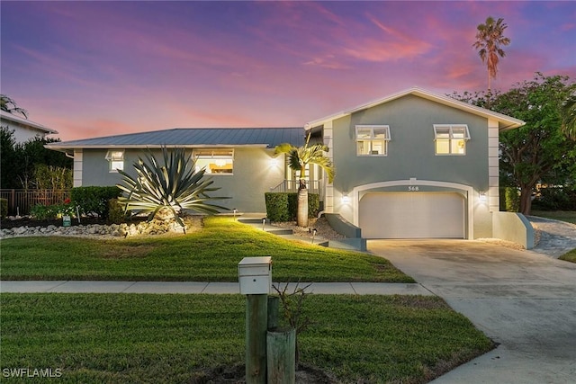 view of front of house with a yard and a garage