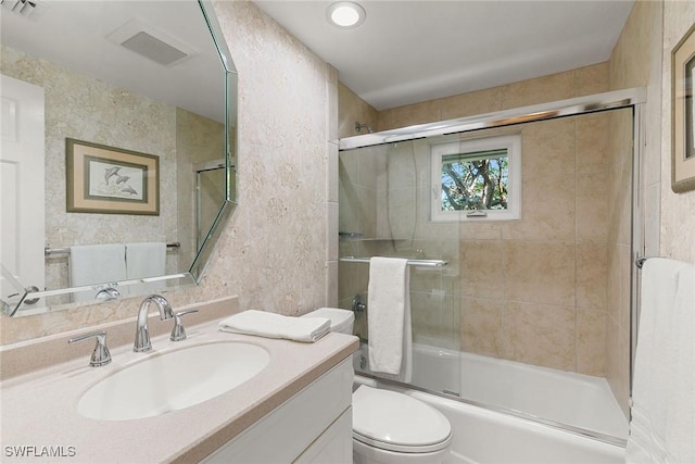 full bathroom with vanity, toilet, and bath / shower combo with glass door