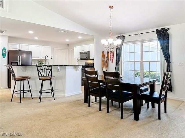 carpeted dining area with a notable chandelier, lofted ceiling, and sink