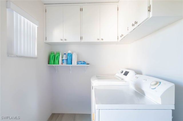 clothes washing area with cabinets and independent washer and dryer