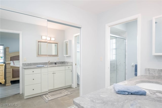 bathroom featuring vanity, tile patterned floors, and a shower with door