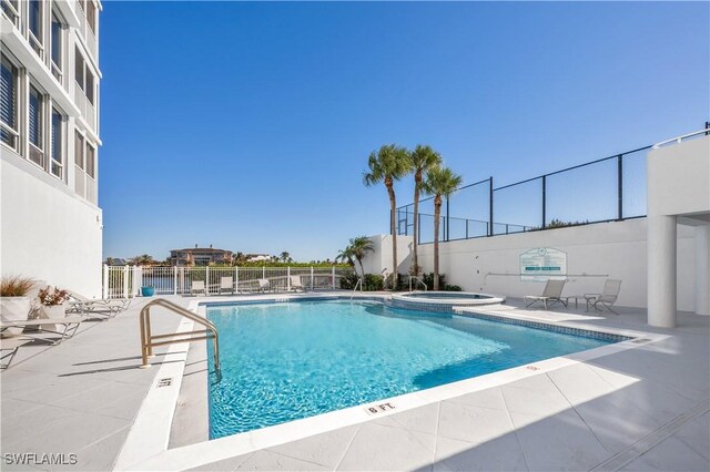 view of swimming pool with a patio and a hot tub