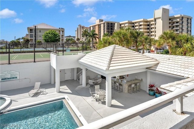 view of swimming pool with a gazebo, tennis court, a patio area, and a bar