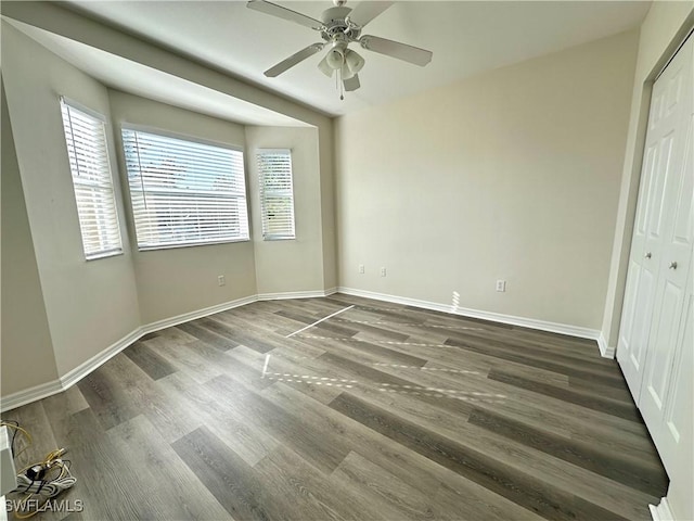 unfurnished bedroom featuring ceiling fan and dark wood-type flooring