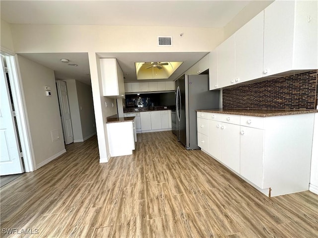 kitchen with decorative backsplash, ceiling fan, light hardwood / wood-style flooring, and white cabinets