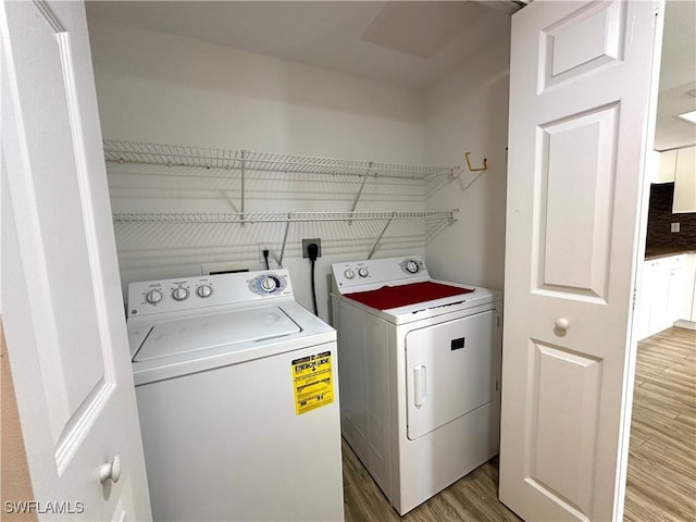 laundry room featuring hardwood / wood-style flooring and separate washer and dryer