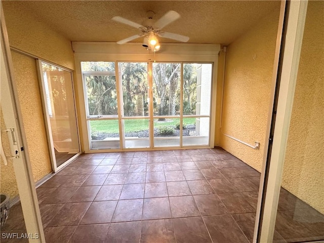 unfurnished sunroom featuring ceiling fan