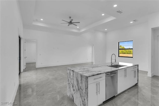 kitchen featuring a center island with sink, dishwasher, a raised ceiling, and white cabinetry