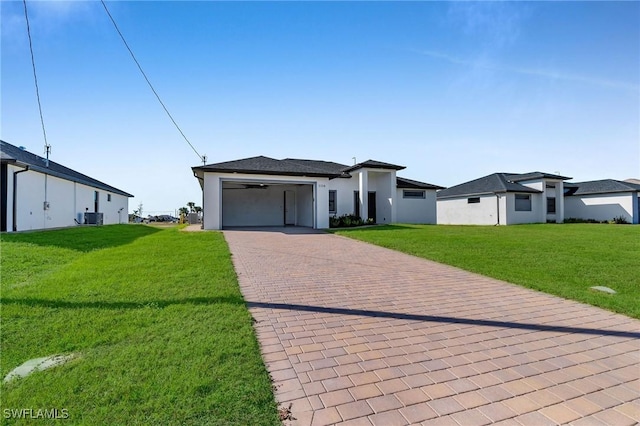 view of front facade with a garage, a front lawn, and central air condition unit