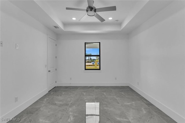 unfurnished room with a tray ceiling and ceiling fan