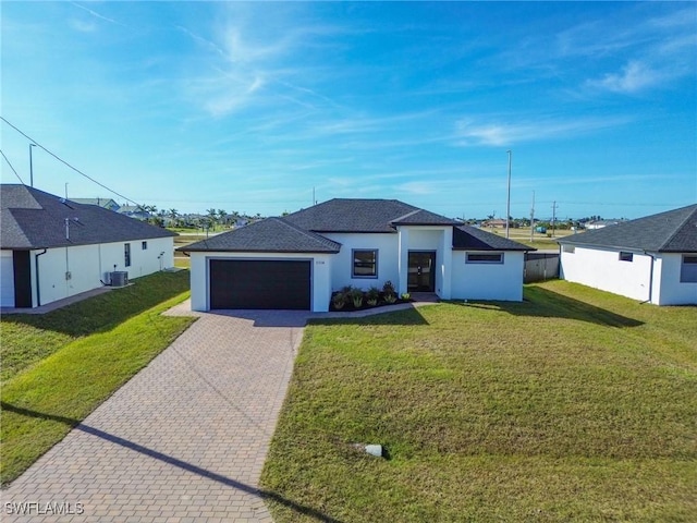 view of front of house with a garage, a front lawn, and cooling unit